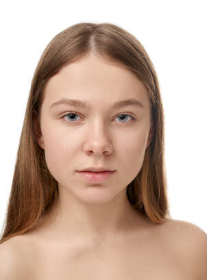 Front view of young girl posing without makeup and with natural nude makeup. Attractive female with blue eyes looking at camera on white isolated background studio. Concept of before and after.