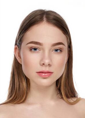 Front view of young girl posing without makeup and with natural nude makeup. Attractive female with blue eyes looking at camera on white isolated background studio. Concept of before and after.